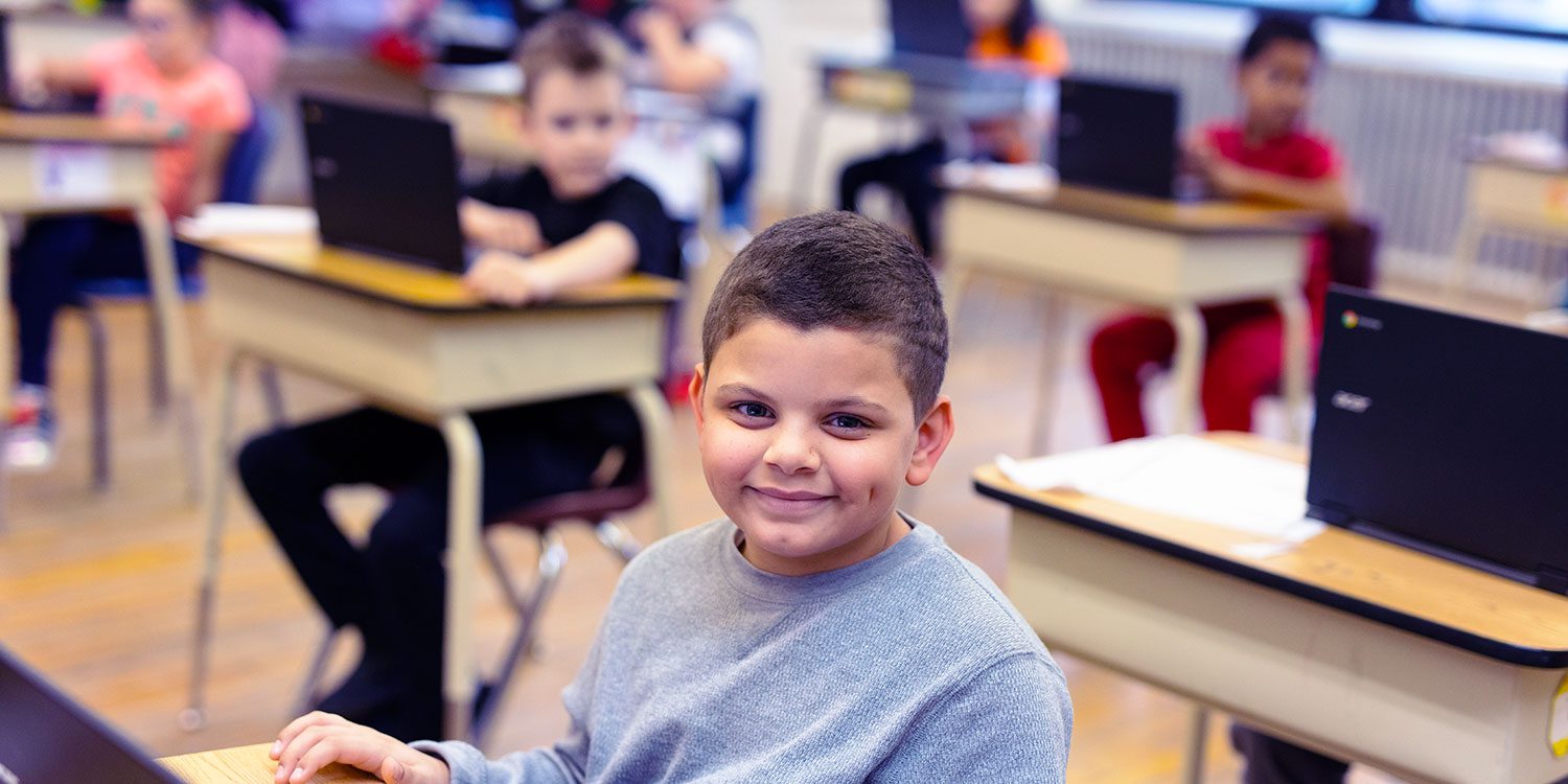 Smiling student working at a desk.